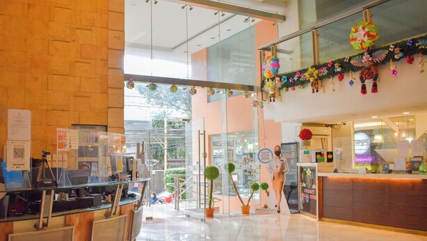A hotel reception area with a glass partition, a reception desk, and a staircase leading to an upper level. - Birchtower by Jeizel Manila City By Zuzu (Manila)