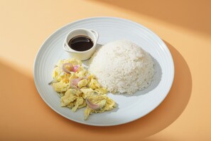 A plate with white rice, scrambled eggs with onions, and a small bowl of sauce. - Hotel Juliano By Zuzu (Manila)