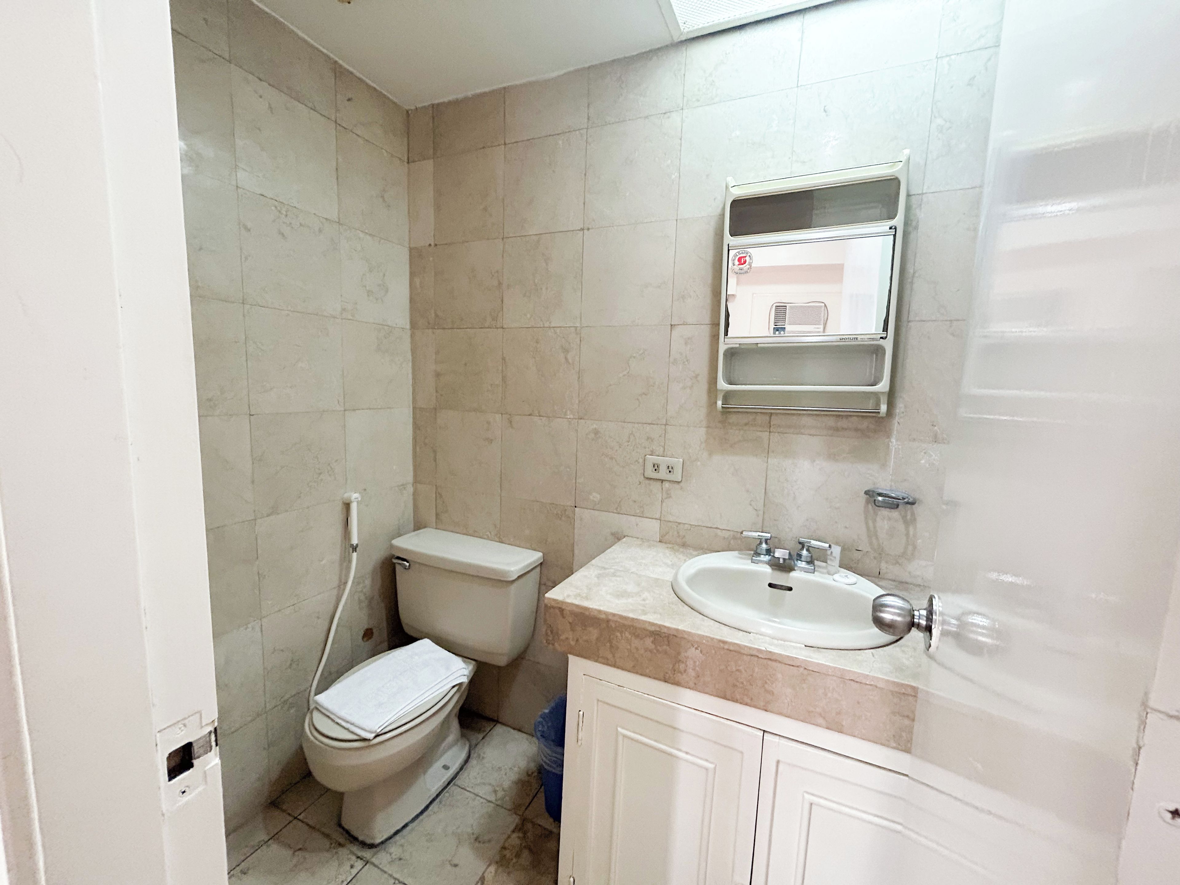 Ein kleines Badezimmer mit Toilette, Waschbecken und Spiegel.