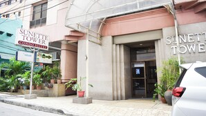 Un immeuble sur lequel on peut lire l’inscription suivante : « SUNETTE TOWER, appartements de luxe ».