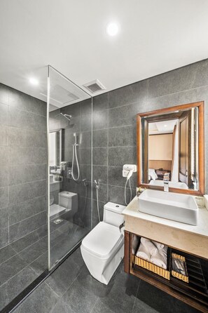 A modern bathroom with a glass-enclosed shower, a white toilet, and a vanity with a mirror. - Palazzo 3 (Da Nang Municipality)