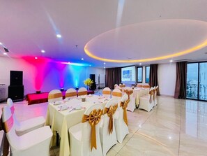 A conference room with tables and chairs, a podium, and a large screen. - Palazzo 3 (Da Nang Municipality)