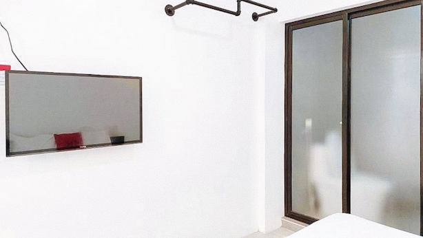 A room with a bed, a mirror, and a sliding glass door. - Reddoorz @ San Antonio Binan Laguna (Biñan City)