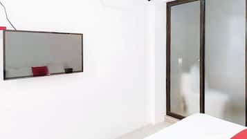 A room with a bed, a mirror, and a sliding glass door.