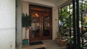 A wooden door with glass panels, a potted plant, and a tiled entrance area.