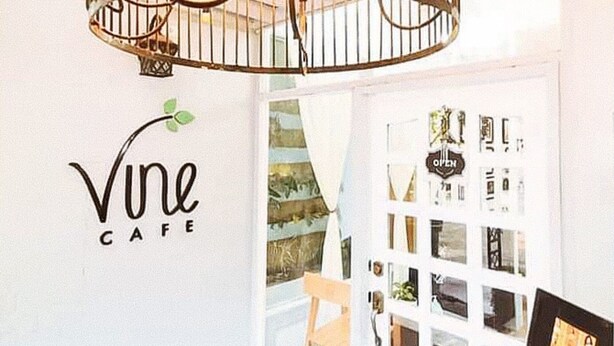 A cafe interior with a sign reading "Vine Cafe" and a door with a sign that says "OPEN".