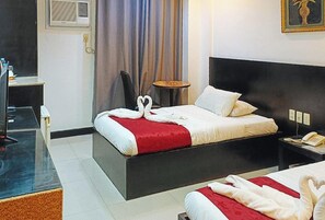 A hotel room with a bed, bedside table, and a small round table. - Check Inn Hotel Dumaguete City By Reddoorz (Dumaguete)