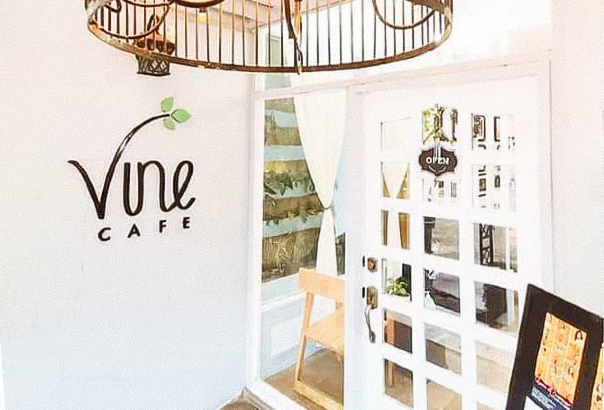 A cafe interior with a sign reading "Vine Cafe" and a door with a sign that says "OPEN".