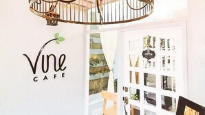 A cafe interior with a sign reading "Vine Cafe" and a door with a sign that says "OPEN". - Check Inn Hotel Dumaguete City By Reddoorz (Dumaguete)