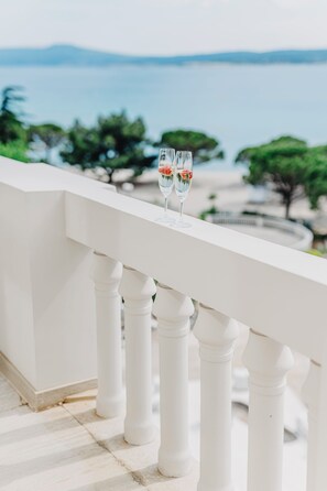 A balcony with white balustrades overlooking a scenic view of the sea and trees. - Miramare (Crikvenica)