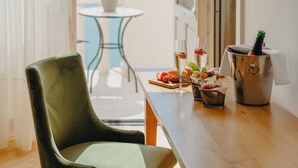 A room with a wooden table, a green chair, a small potted plant, a bottle of champagne, and a glass of wine. - Miramare (Crikvenica)