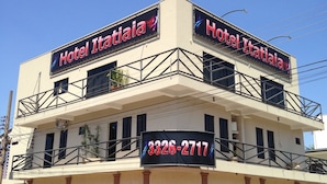 Kaksikerroksinen rakennus, jossa on parvekkeet ja kyltti, jossa lukee ”Hotel Itatiaia” sekä puhelinnumero.