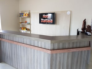 A hotel reception desk with a digital sign displaying "Hotel Italiaia". - Hotel Itatiaia (Tangará da Serra)