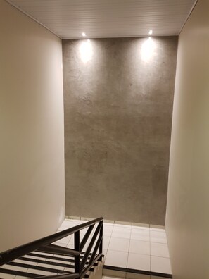 Eine Treppe mit Metallgeländer, die zu einem gefliesten Boden führt.