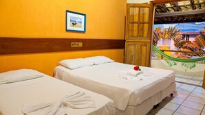 Two single beds with white linens, a wooden headboard, a framed picture on the wall, and a hammock visible through an open door. - Chaua Porto Hotel (Porto Seguro)