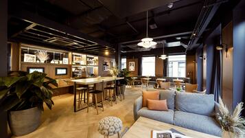 A modern interior with a bar area, seating, and a large plant.