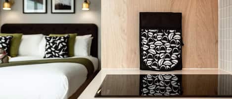 A hotel room with a bed, a bedside table, and a wall-mounted artwork.