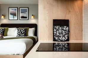 A hotel room with a bed, a bedside table, and a wall-mounted artwork. - Wilde Aparthotels London Aldgate Tower Bridge (London)