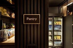 A pantry area with a sign labeled "Pantry" and shelves stocked with various food items. - Wilde Aparthotels London Aldgate Tower Bridge (London)