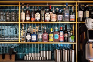 A bar with multiple shelves of liquor bottles and glasses.
