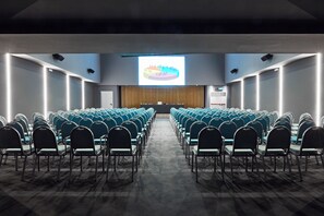 A conference room with rows of chairs facing a projection screen at the front. - The Building (Rome)
