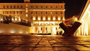 A hotel with multiple floors, balconies, and a well-lit facade.