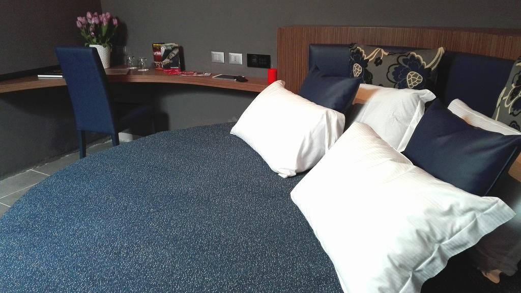 Une chambre d’hôtel avec un lit à la forme arrondie, un bureau et une chaise.