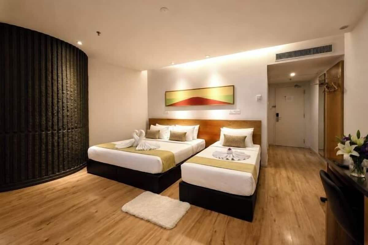 Ein Hotelzimmer mit zwei Betten, einem großen Kunstwerk an der Wand und Holzboden.