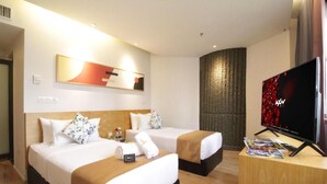 Une chambre d’hôtel avec deux lits, une télévision et un bureau en bois.