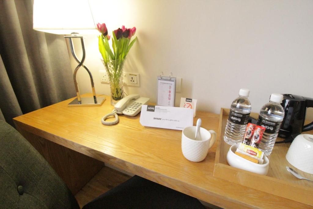 A hotel reception desk with a telephone, a notepad, a mug, and bottled water.