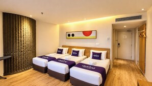 Une chambre d’hôtel avec trois lits, un plancher en bois, une grande fenêtre donnant sur un beau paysage et un design moderne.