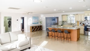 A modern kitchen with a central island, bar stools, and stainless steel appliances. - Spacious 4 bedroom Fort Myers house , Pool, great for Families, Sports or Golf! (Fort Myers)