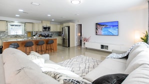 A modern kitchen with a central island, bar stools, and a large island bar. - Spacious 4 bedroom Fort Myers house , Pool, great for Families, Sports or Golf! (Fort Myers)