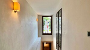 A narrow hallway with a light fixture on the left and a framed artwork on the right. - 7-bedroom Chalet With Private Pool (Saanen)