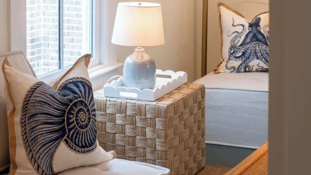 Une chambre confortable avec un lit, une lampe de chevet et une fenêtre donnant sur des immeubles.