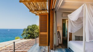 A bedroom with a view of the sea, a wooden pergola, and a bed with a canopy. - Villa Mare di Spartaia (Marciana)