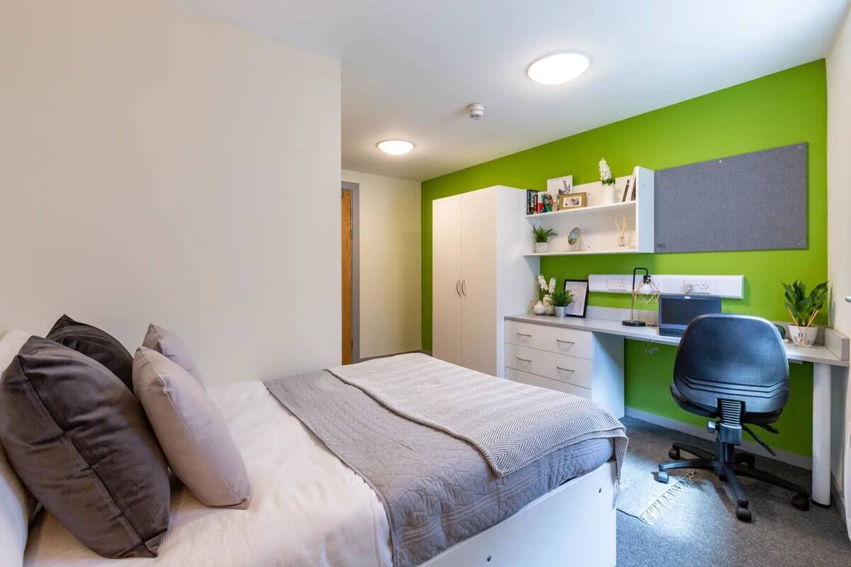 Une chambre à coucher avec un lit, un bureau et une chaise.