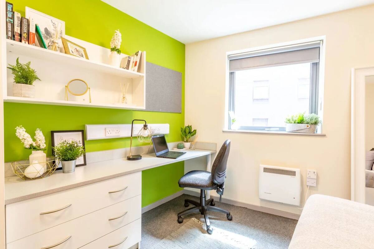 Un espace de bureau moderne comprenant un bureau, une chaise et des étagères remplies de livres et de plantes.