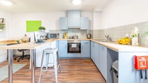 A modern kitchen with light blue cabinets, a wooden countertop, a built-in oven, and a sink. - For Students Only Bryson Court (Newcastle-upon-Tyne)