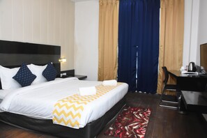 Een hotelkamer met een bed, een bureau, een stoel en een bureaulamp.