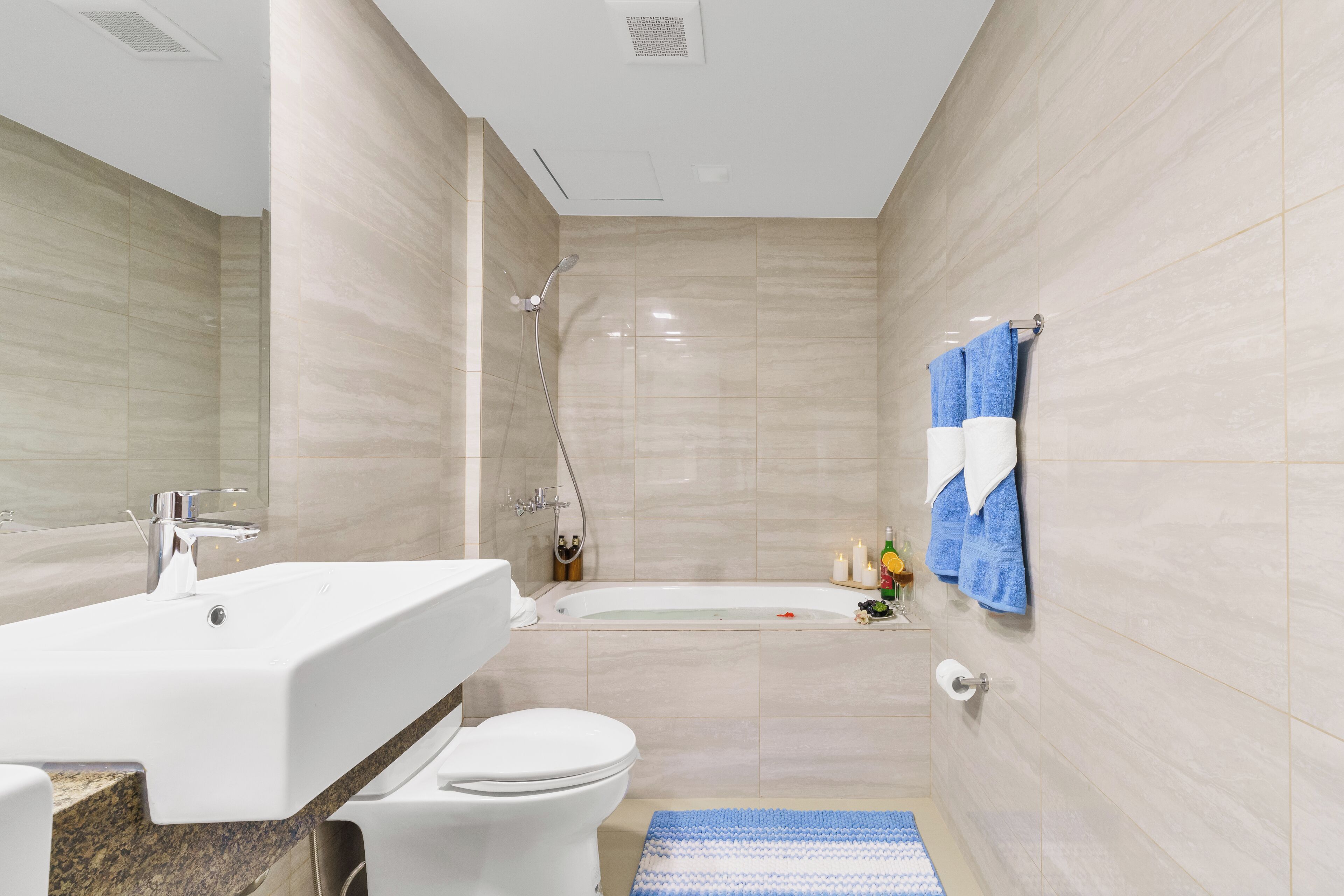 A modern bathroom with a large sink, toilet, and bathtub.