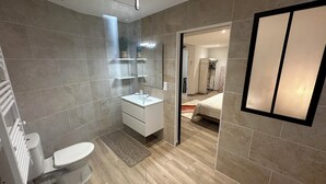 Ein modernes Badezimmer mit Toilette, Waschbecken und Duschbereich.