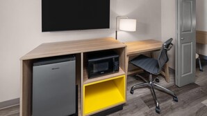 A compact kitchenette with a refrigerator, microwave, and a yellow storage shelf. - Days Inn by Wyndham Farmington NM (Farmington)