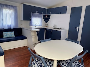 A compact living space with a kitchenette, a dining table, and a sofa. - Malgrat Retreat Near Beach (Mont-roig del Camp)