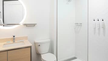 Un baño moderno con inodoro, lavamanos y ducha.