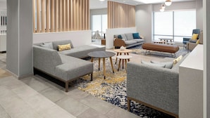 Un espace de détente moderne avec des canapés, une table basse et un tapis à motifs.