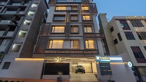 A modern hotel with a geometric facade, multiple balconies, and a car entrance. - Treebo Premium Lalitha, RK Beach (Visakhapatnam)