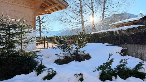 A snow-covered outdoor area with a wooden building and trees. - Contemporary Swiss Escape (Gsteig)