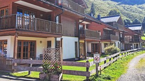 A row of wooden chalets with balconies, set against a mountainous backdrop. - Schönblick Mountain Resort & Spa by Interhome (Rauris)