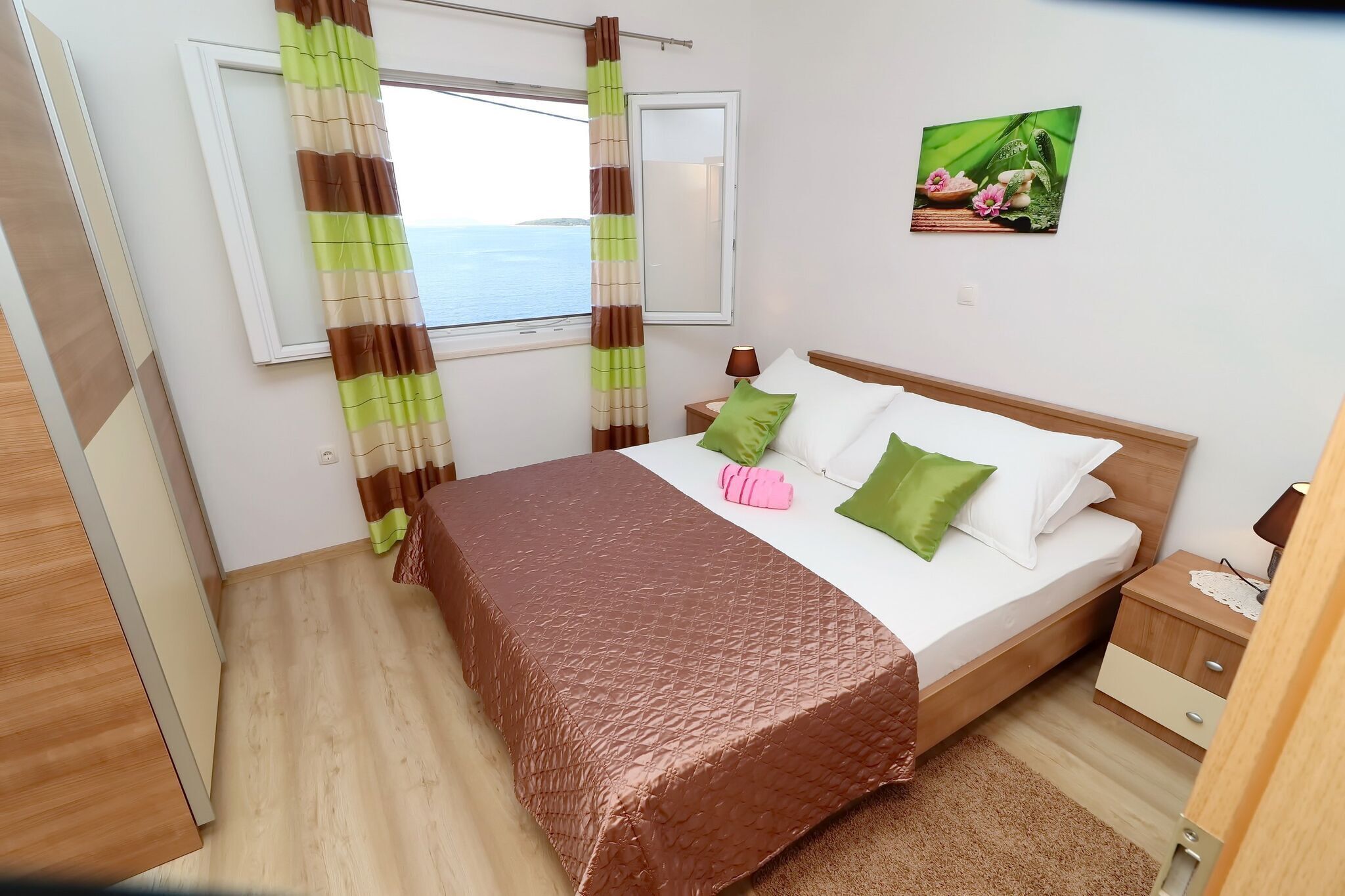 Ein Schlafzimmer mit Bett, Nachttisch und einem Fenster mit Vorhängen.